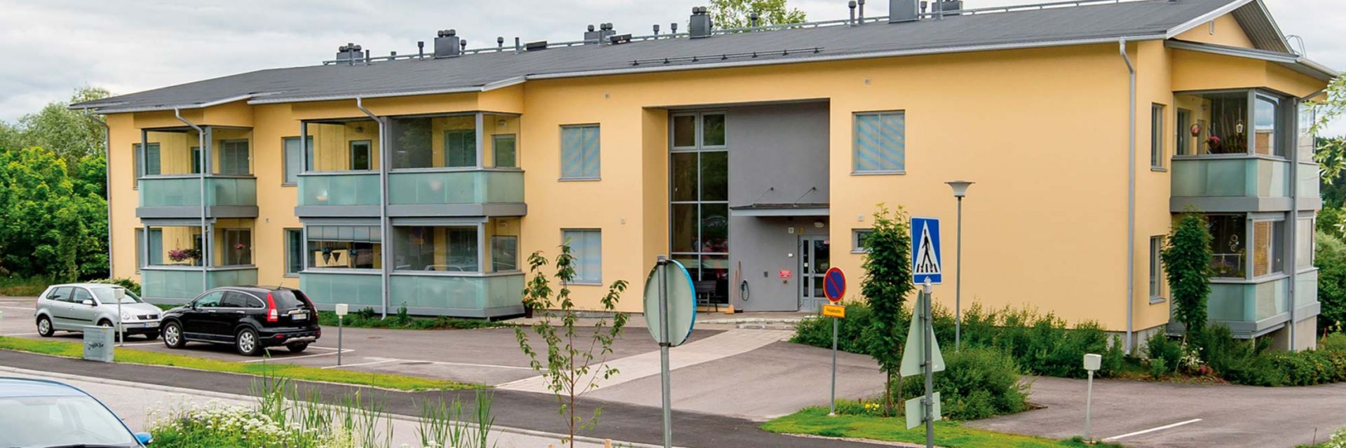 Seniorhuset Sofie, en tvåvåningsbyggnad med balkonger och parkering framför byggnaden.